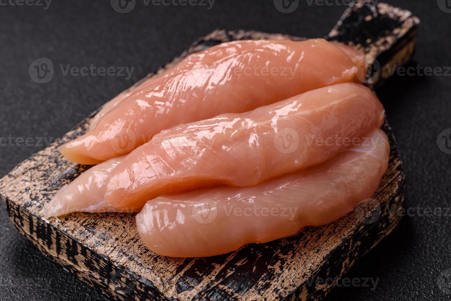 Raw chicken fillet cut into strips with spices and herbs photo