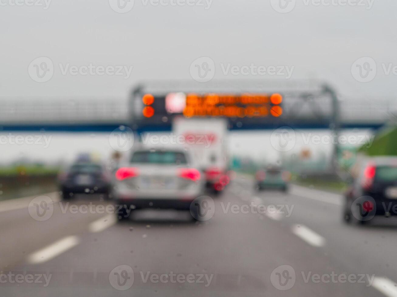 A blurry image of a busy highway with cars and a truck photo