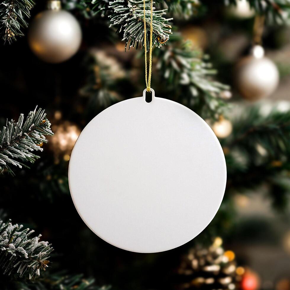 Close up white round ornament with gold thread. In background is a blurred Christmas tree. photo