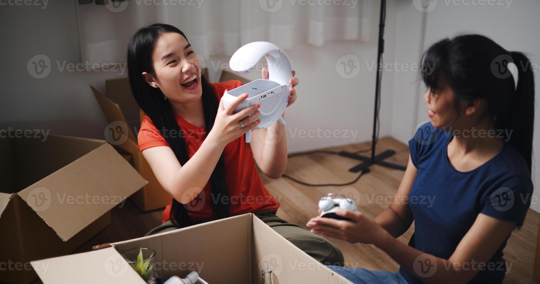 High angle view, Two siblings happily sit on the floor talking as they unpack belongings from boxes to decorate a room in new home. Moving to a new home concept photo