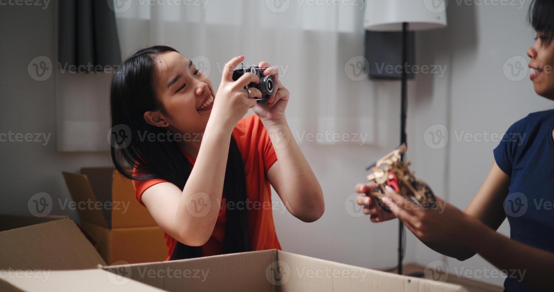 Selective focus, Two siblings happily sit on the floor talking as they unpack belongings from boxes to decorate a room in new home. Moving to a new home concept photo
