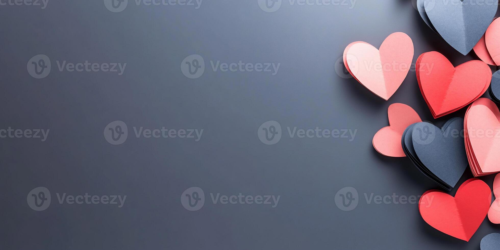 Colorful paper hearts scattered on a dark surface for decoration. photo