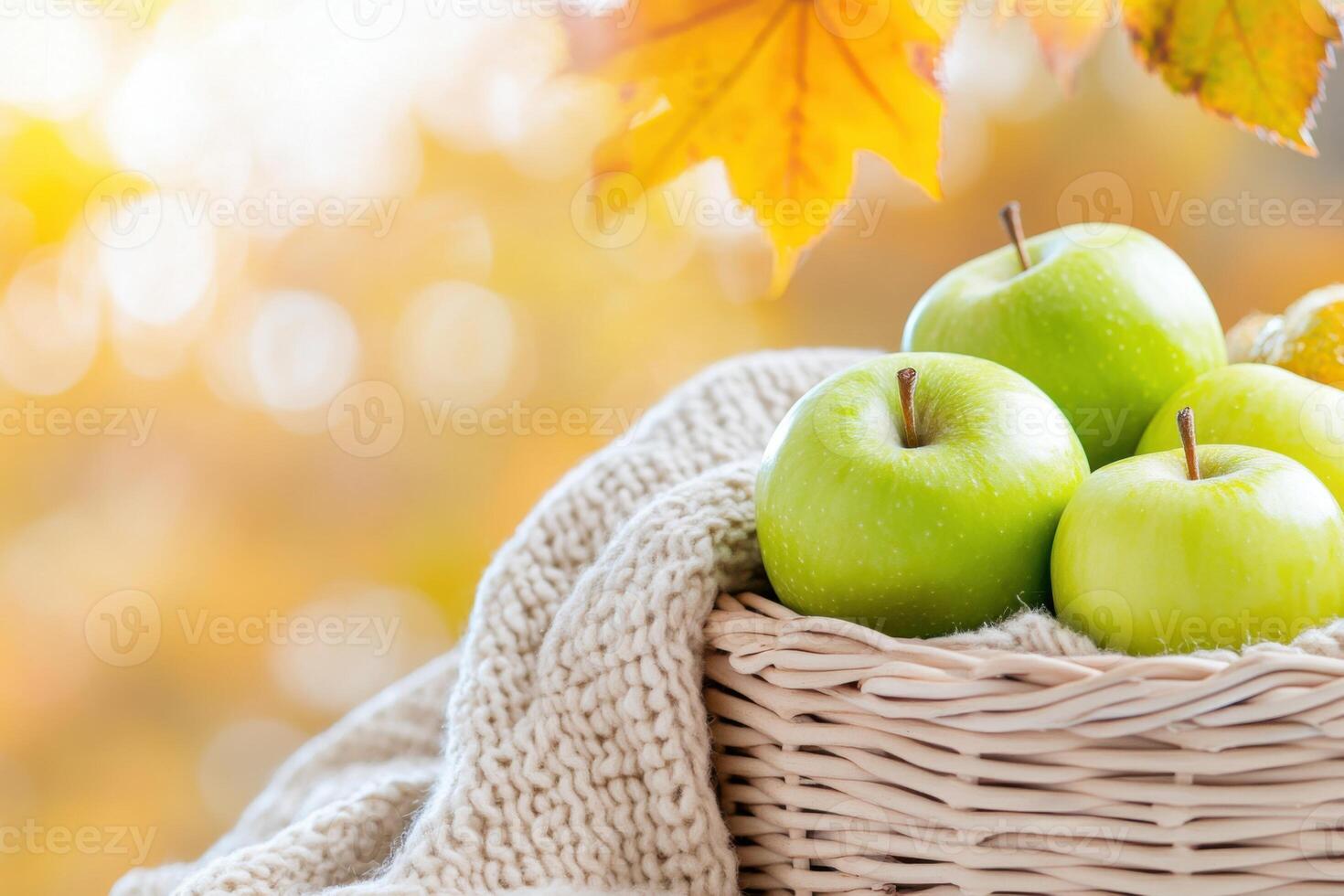 Colorful picnic basket filled with green apples and orange marmalade on a soft blanket outdoors in autumn photo