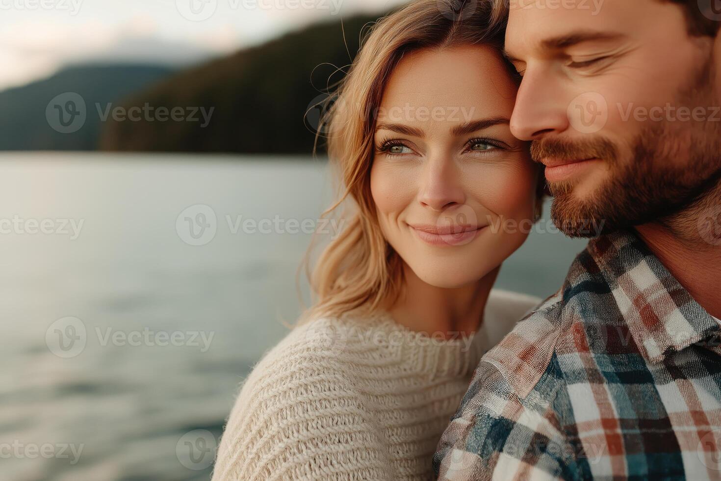 Mature couple embraces near serene lake during sunset, showcasing love and warmth in a minimalistic setting photo