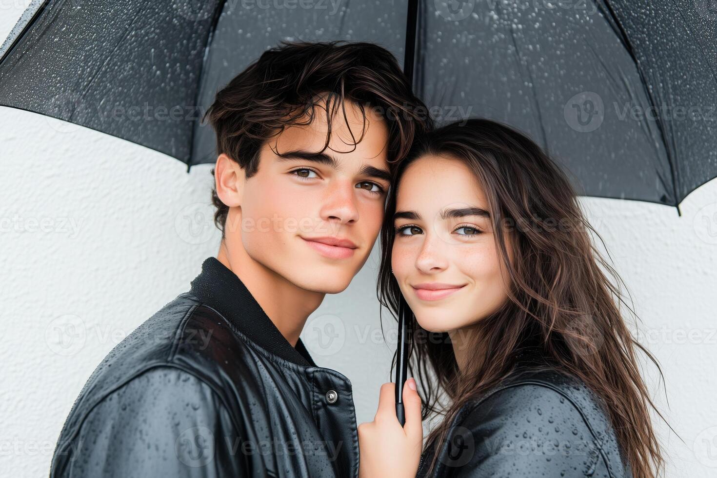 Young couple stands close under umbrella, embracing the rain with smiles in a minimalistic setting photo