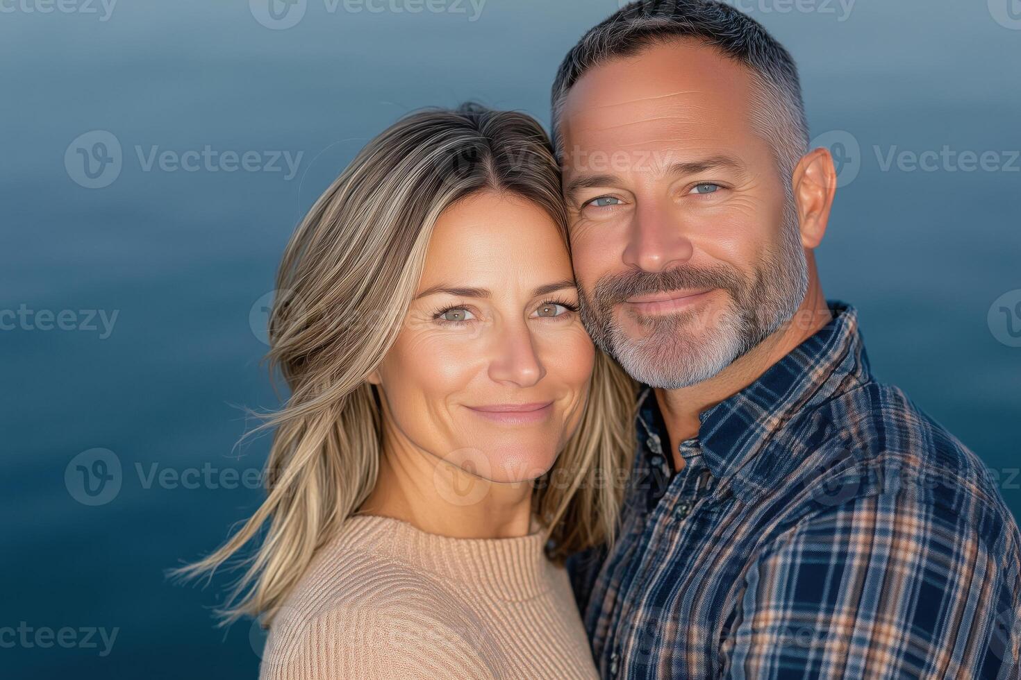 Mature couple embracing by a lake during sunset revealing love and serenity in their expressions photo