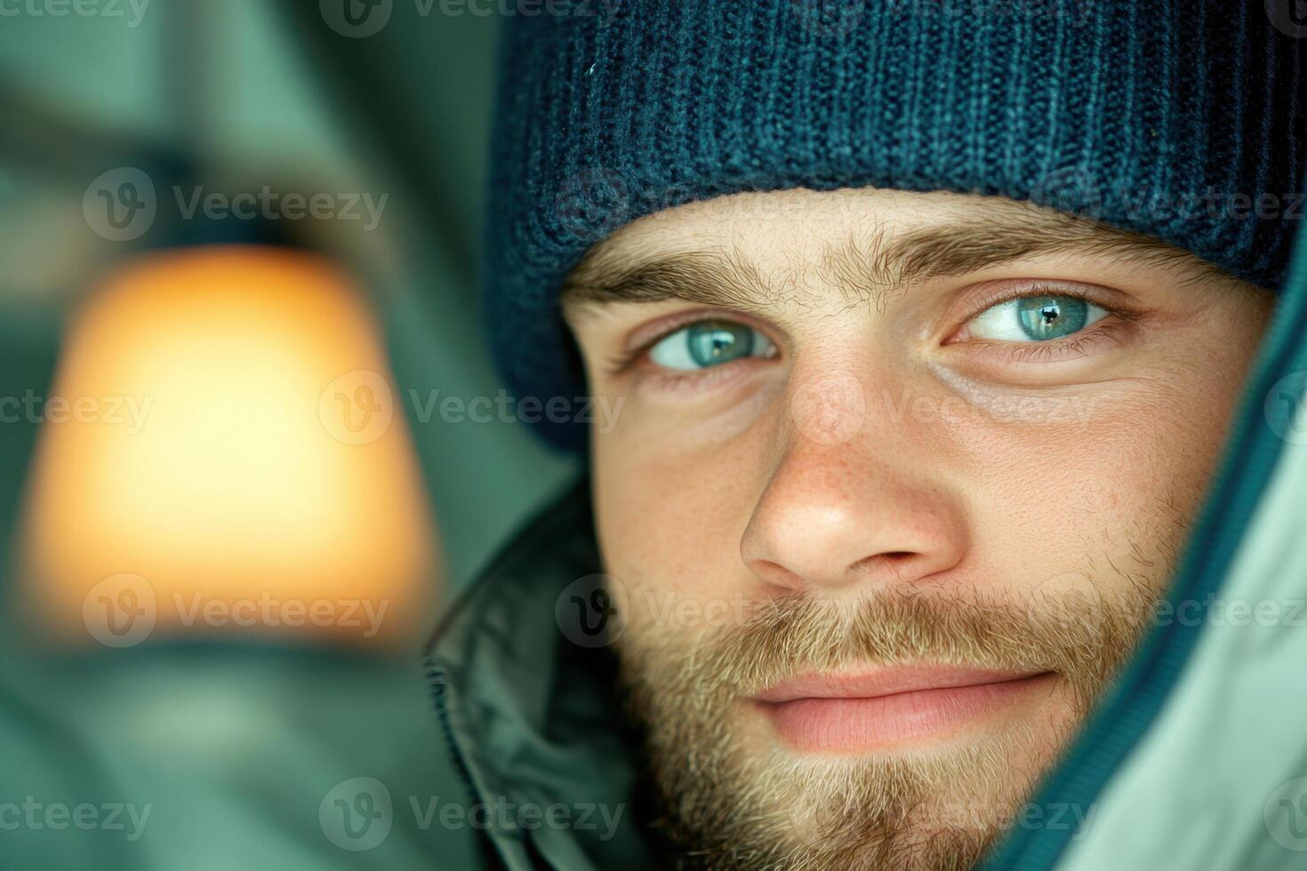 Soldier smiles during call in deployment tent, warm light creates cozy atmosphere in minimalistic setting photo