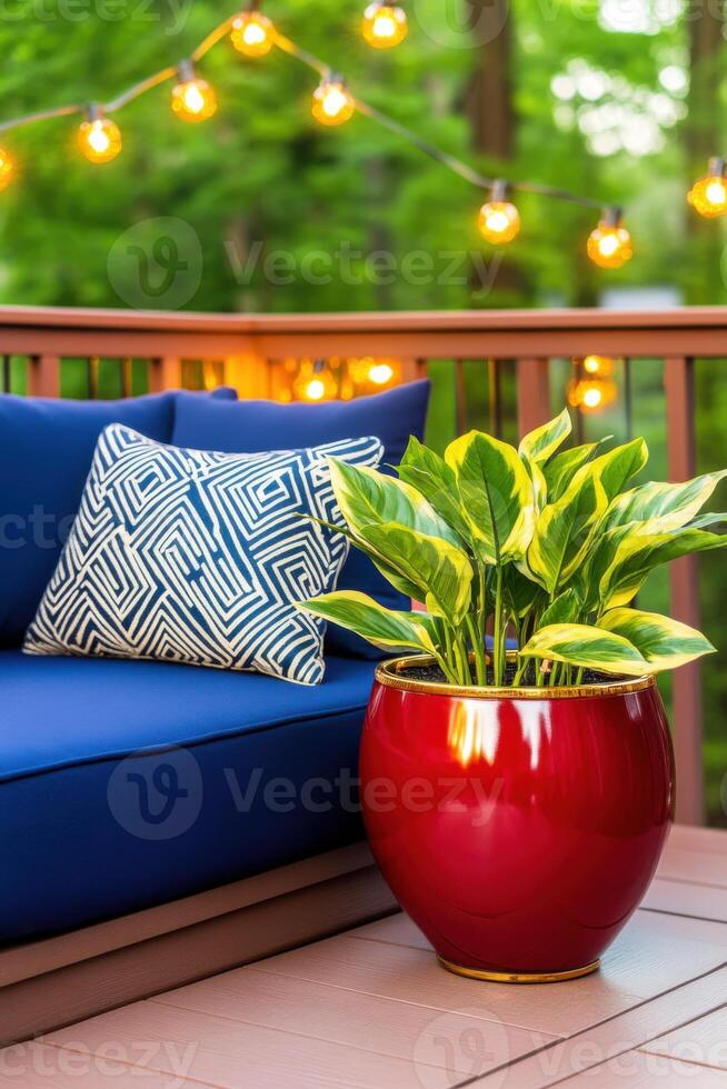 Luxury patio with navy cushions and burgundy planters under golden string lights during a serene evening photo