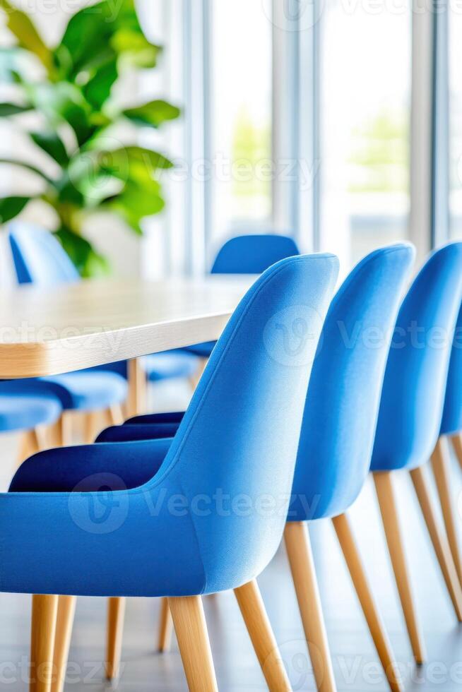 Corporate meeting room featuring a navy conference table and light blue chairs under natural light photo