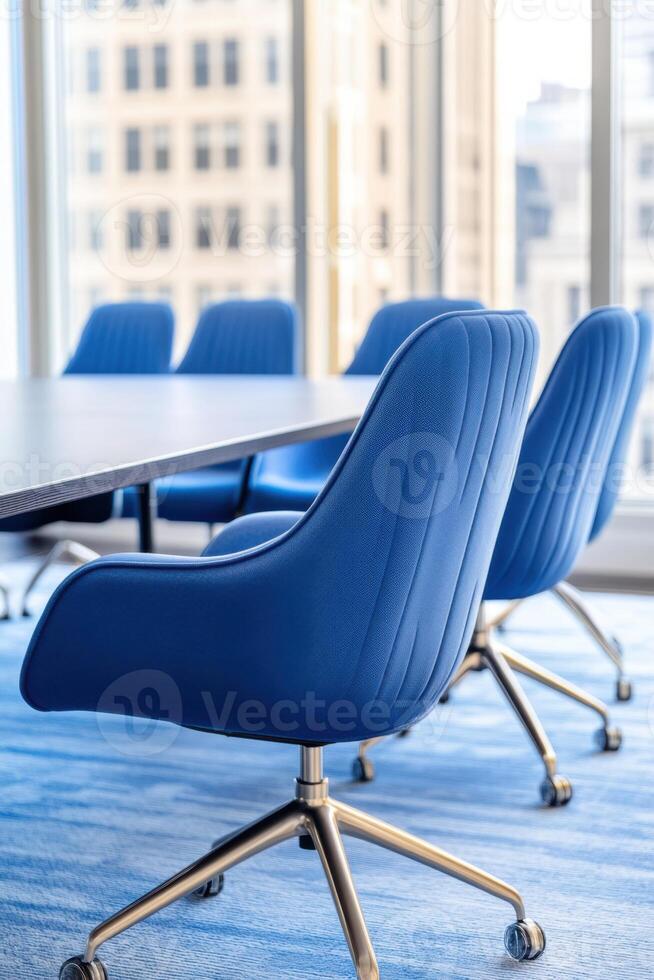 Corporate meeting room designed for collaboration featuring a navy conference table and light blue chairs illuminated by natural light photo