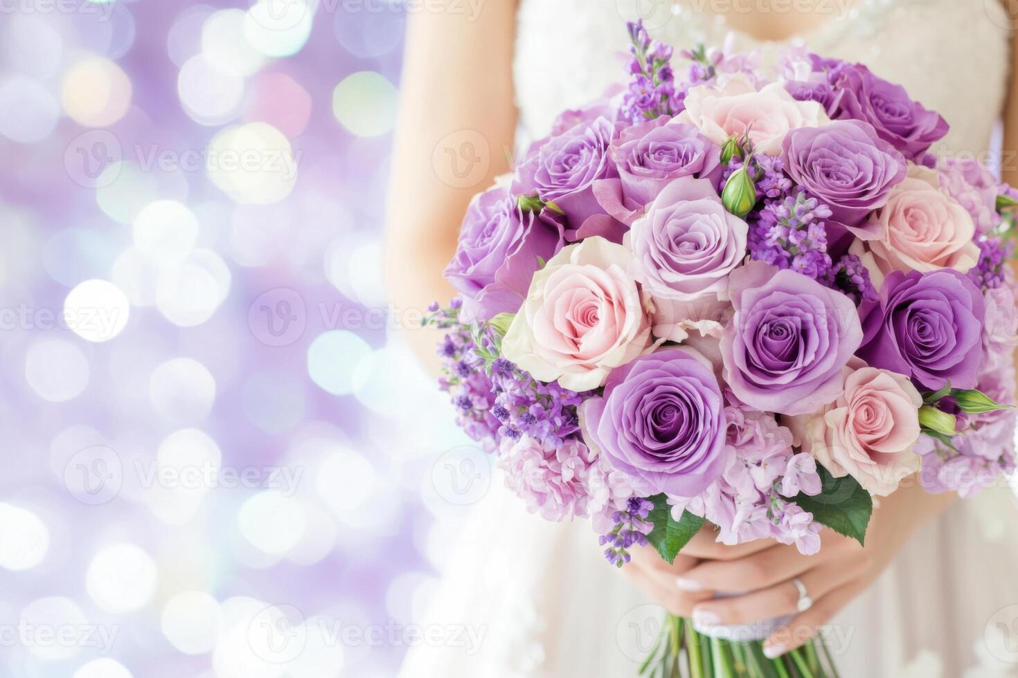 Glamorous wedding with a bride in a taupe gown holding a bouquet of purple and lavender roses in a dreamy setting photo