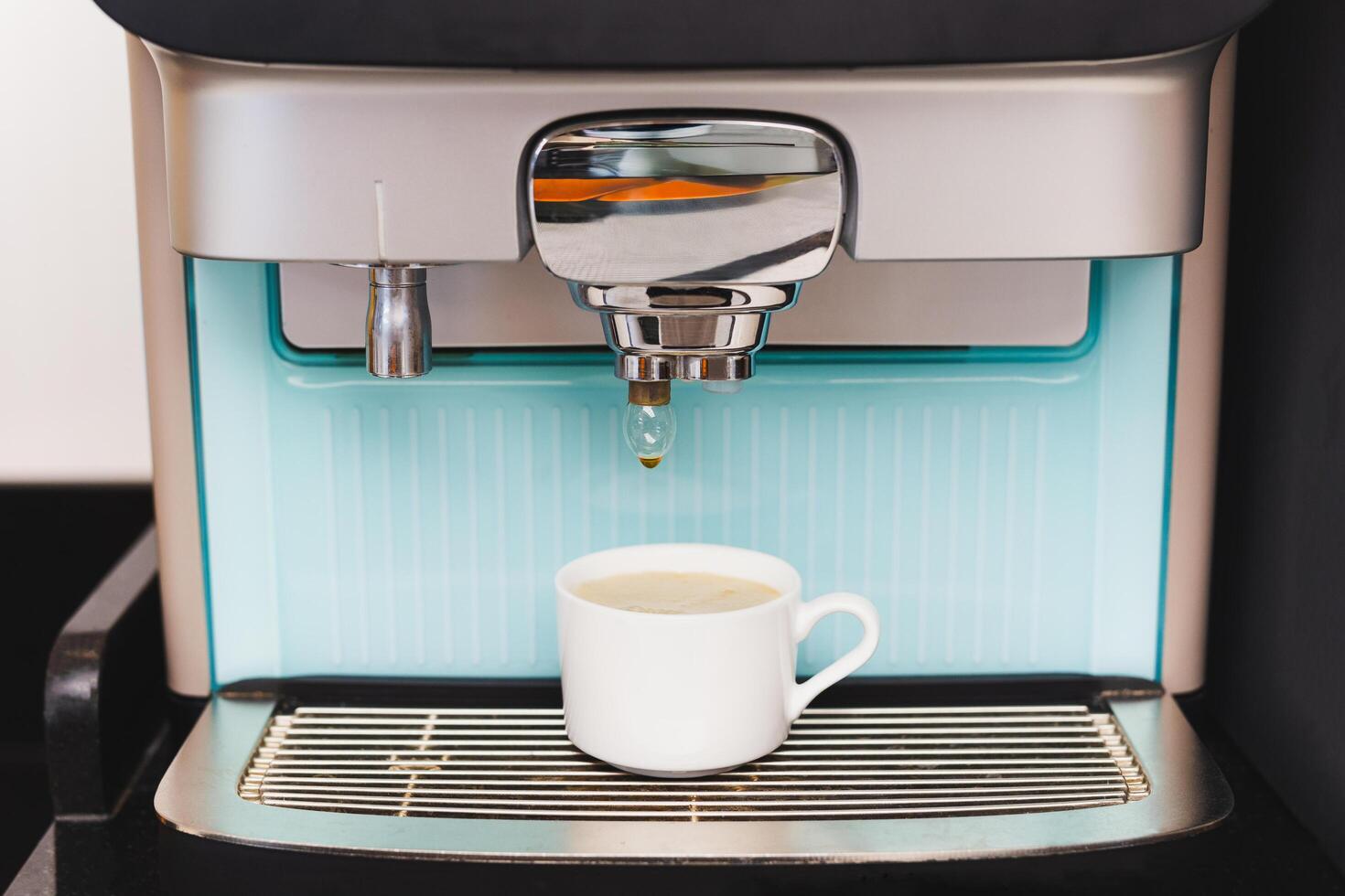 Coffee machine preparing fresh coffee into cups at restaurant. photo