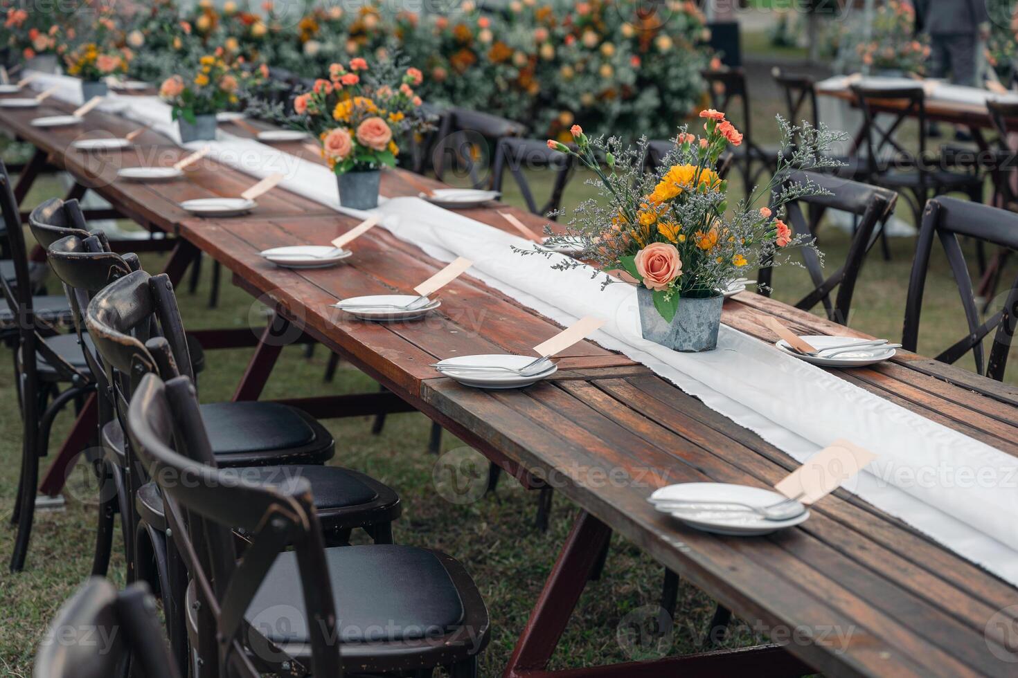 Rustic wedding style, Wooden dining table with flowers decoration and tableware photo