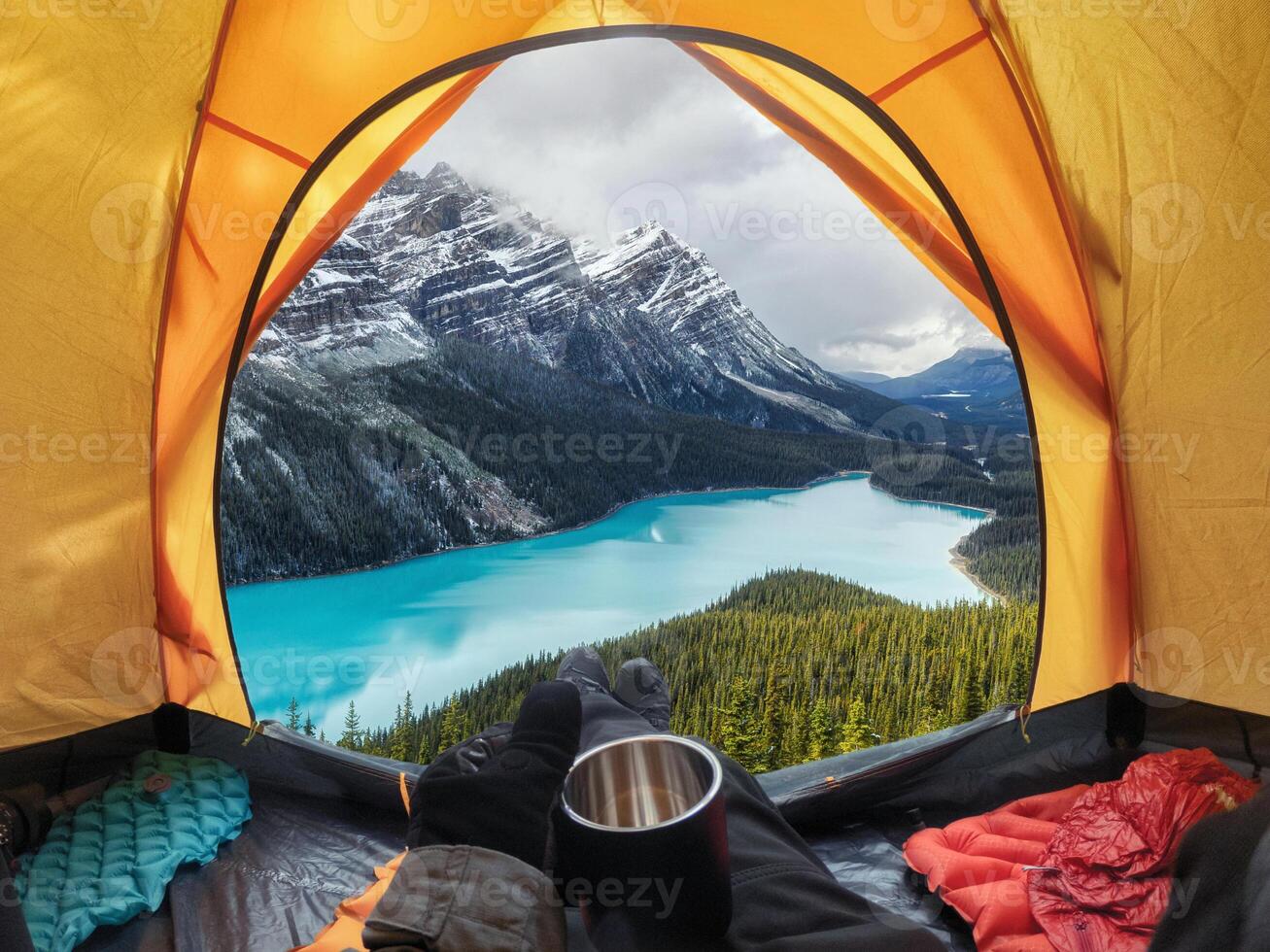 Camping with holding cup in yellow tent open with Peyto Lake in Icefields Parkway photo
