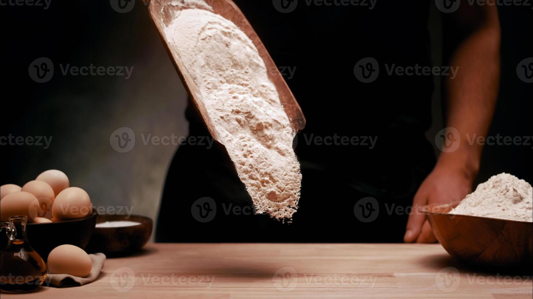 A person is holding a bowl of flour on a table photo