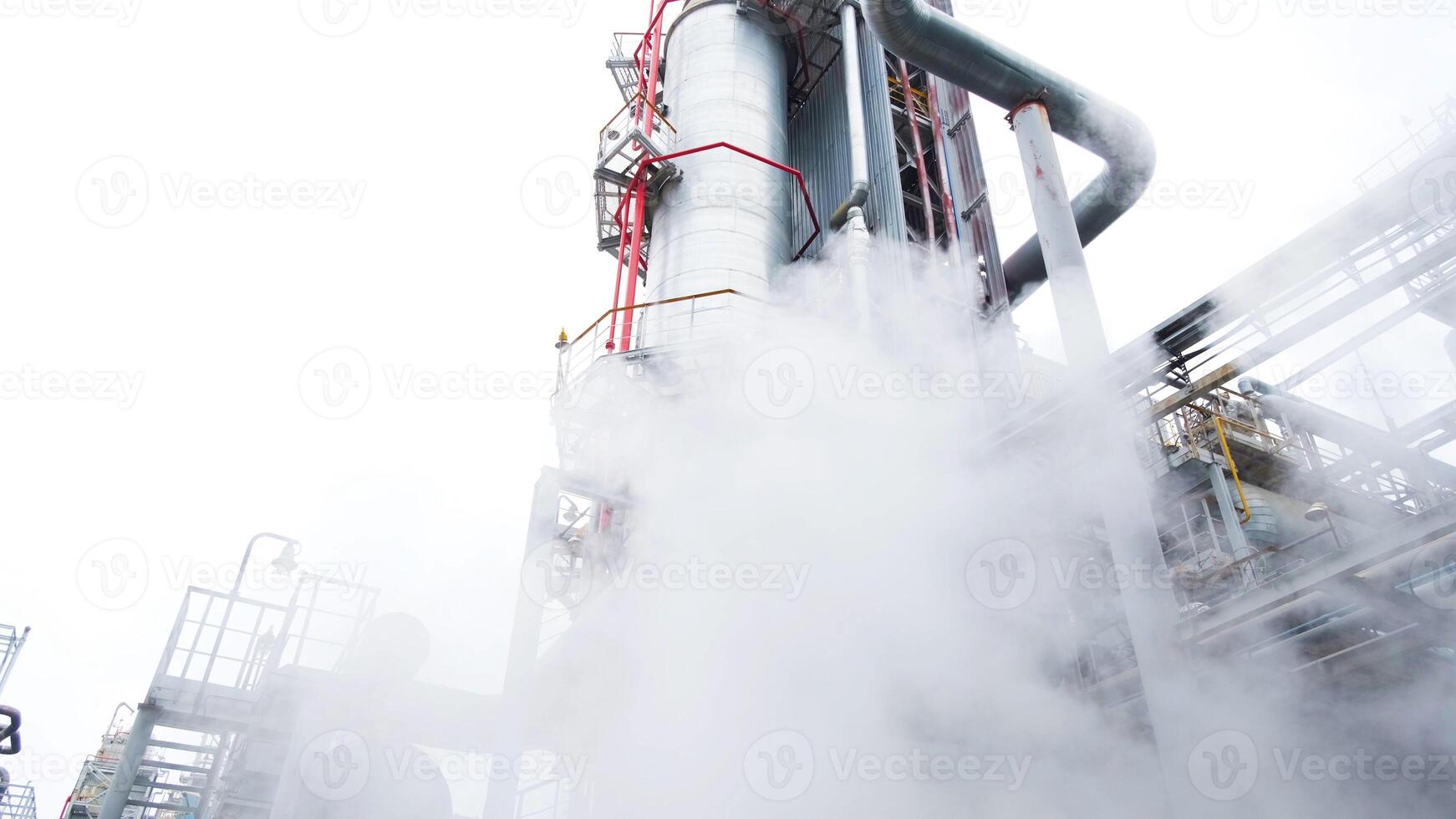 A man standing next to a large steam pipe photo