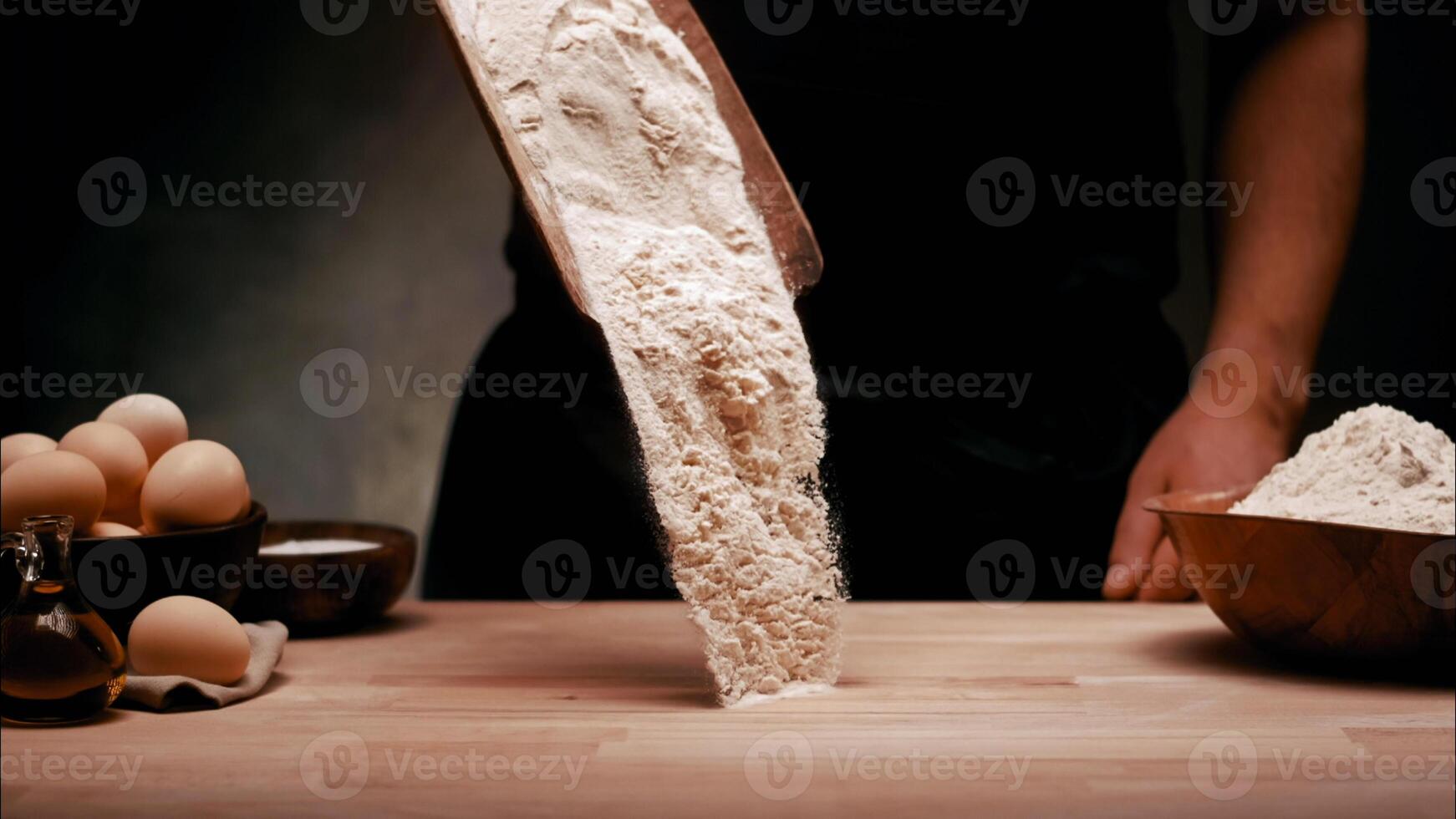 A person is mixing flour on a table photo