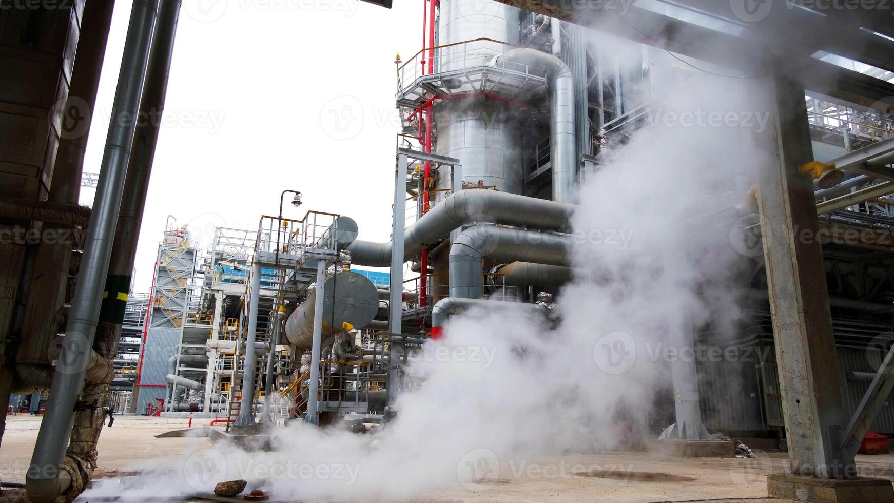 A steam pipe is blowing smoke out of a factory photo