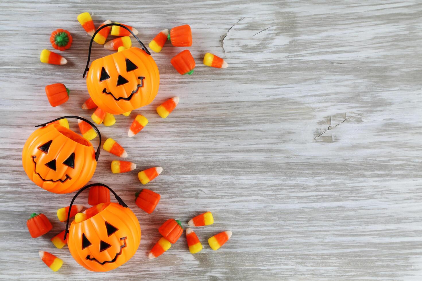 Halloween candy bags and pumpkins on a wooden table photo