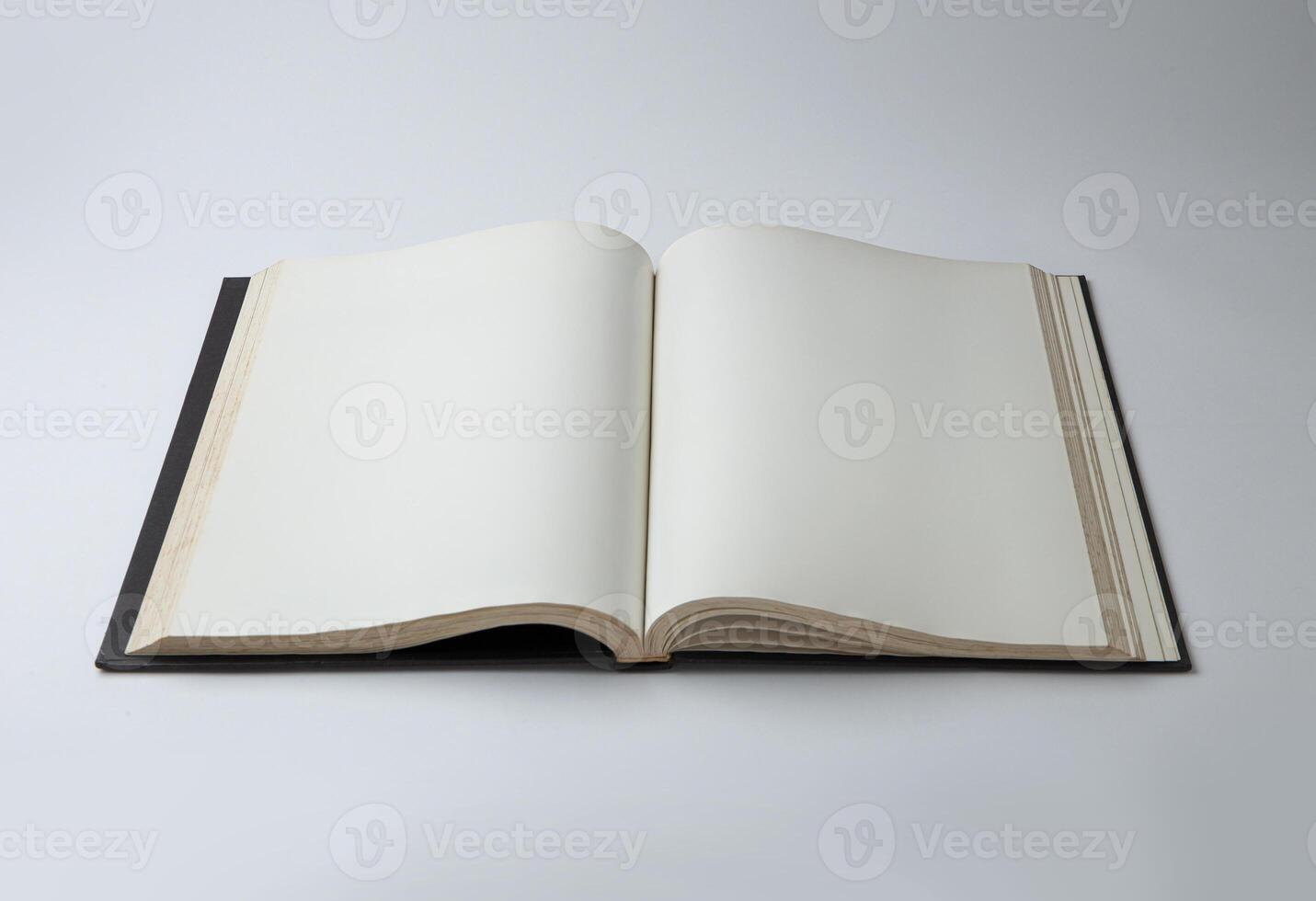 Open empty white paper book laying on white background photo