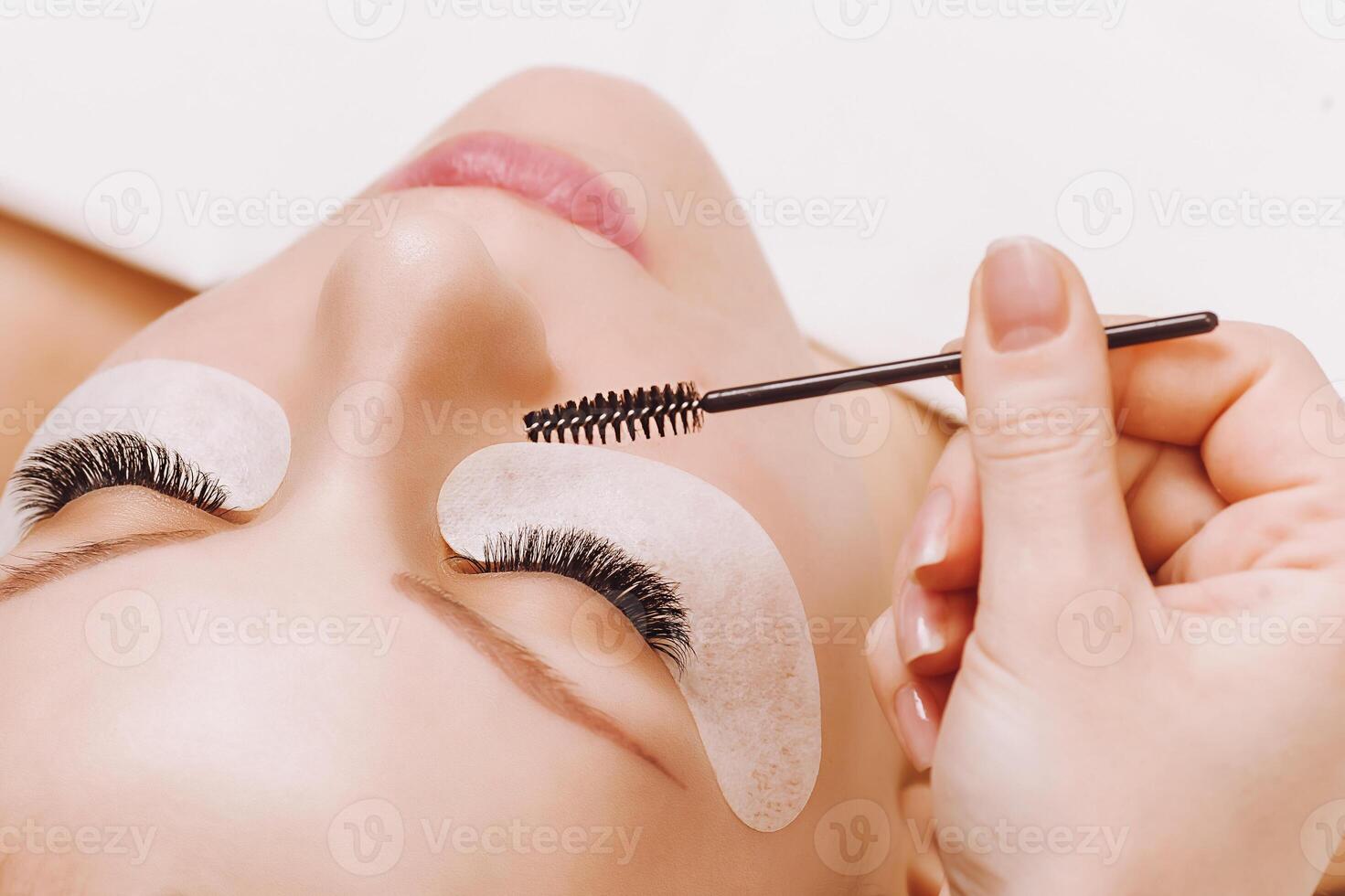 Eyelash Extension Procedure. Woman Eye with Long Eyelashes. Close up, selective focus. photo