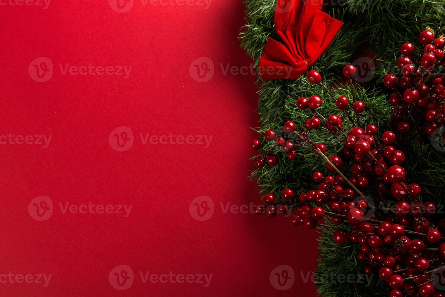 Close-Up of Red Color Ornaments on Evergreen Pine with Red Wall Background photo