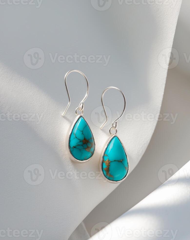 Handmade silver drop earrings feature stunning turquoise accents and an artisanal texture captured in soft natural light photo