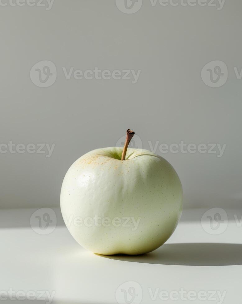 A white apple sitting on a table photo