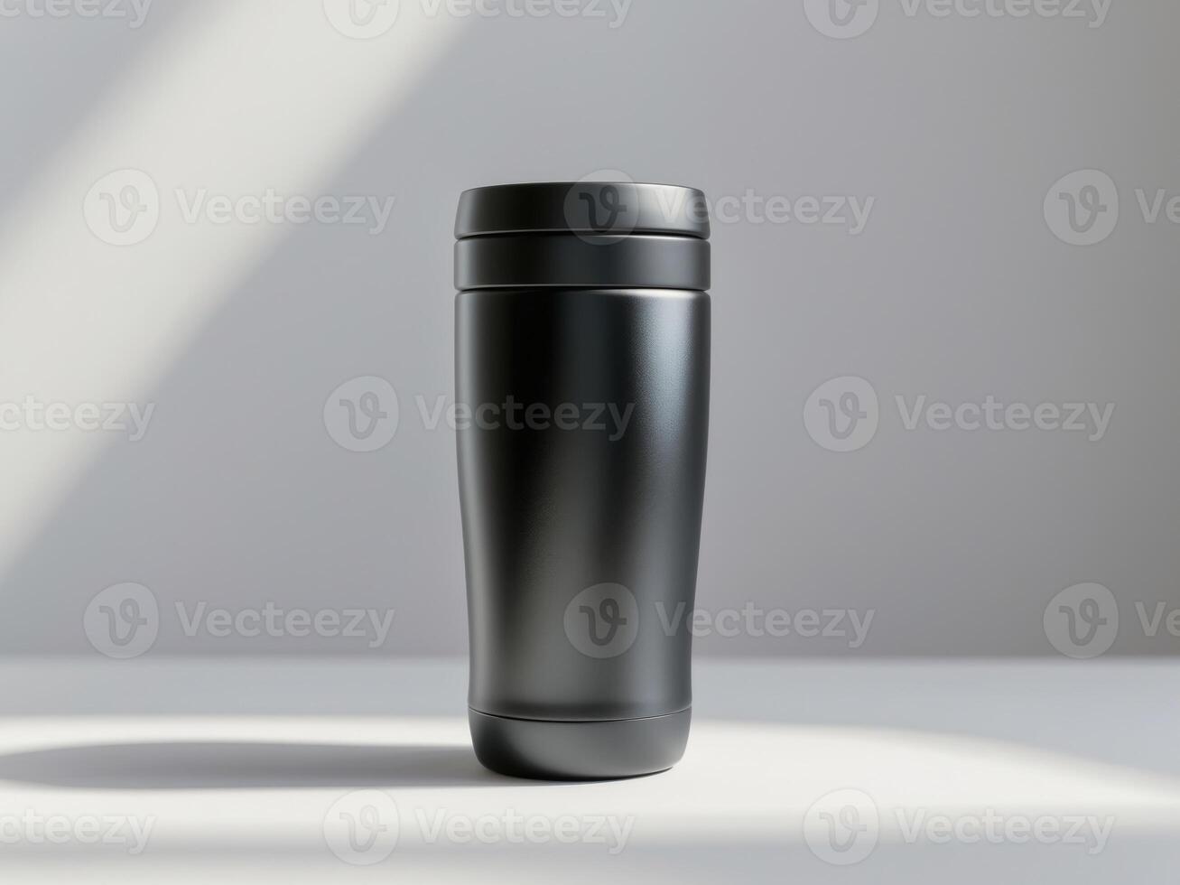 A black travel mug on a table with a light photo