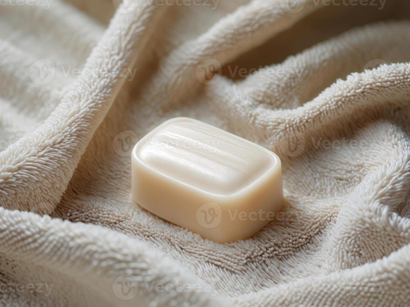 A white soap bar sitting on a towel photo