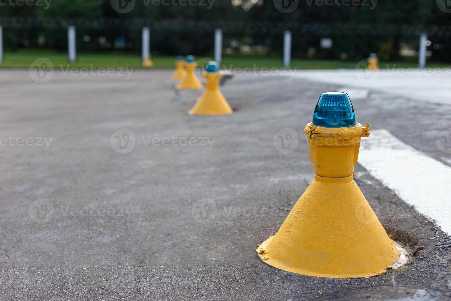 Row of yellow airfield ground lights with blue tops, photo