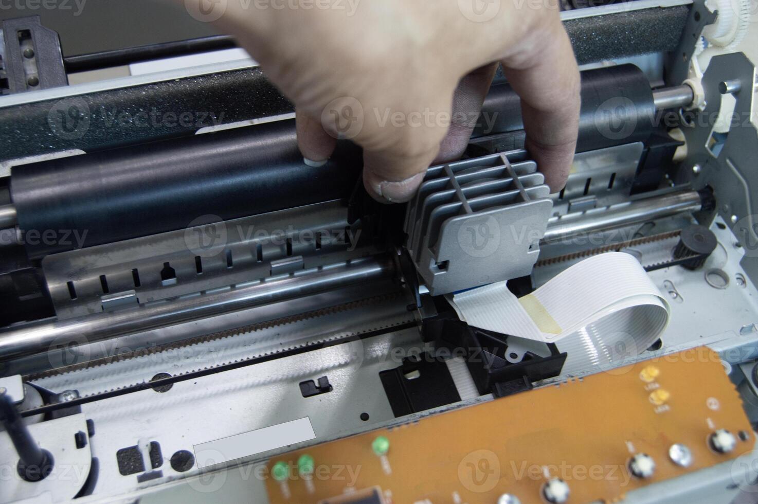 Top view of technician inspecting and repairing printer. photo
