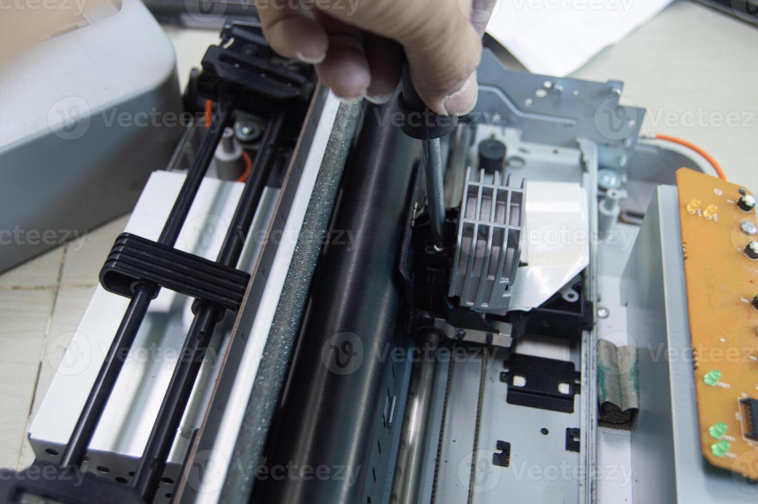 Top view of technician inspecting and repairing printer. photo