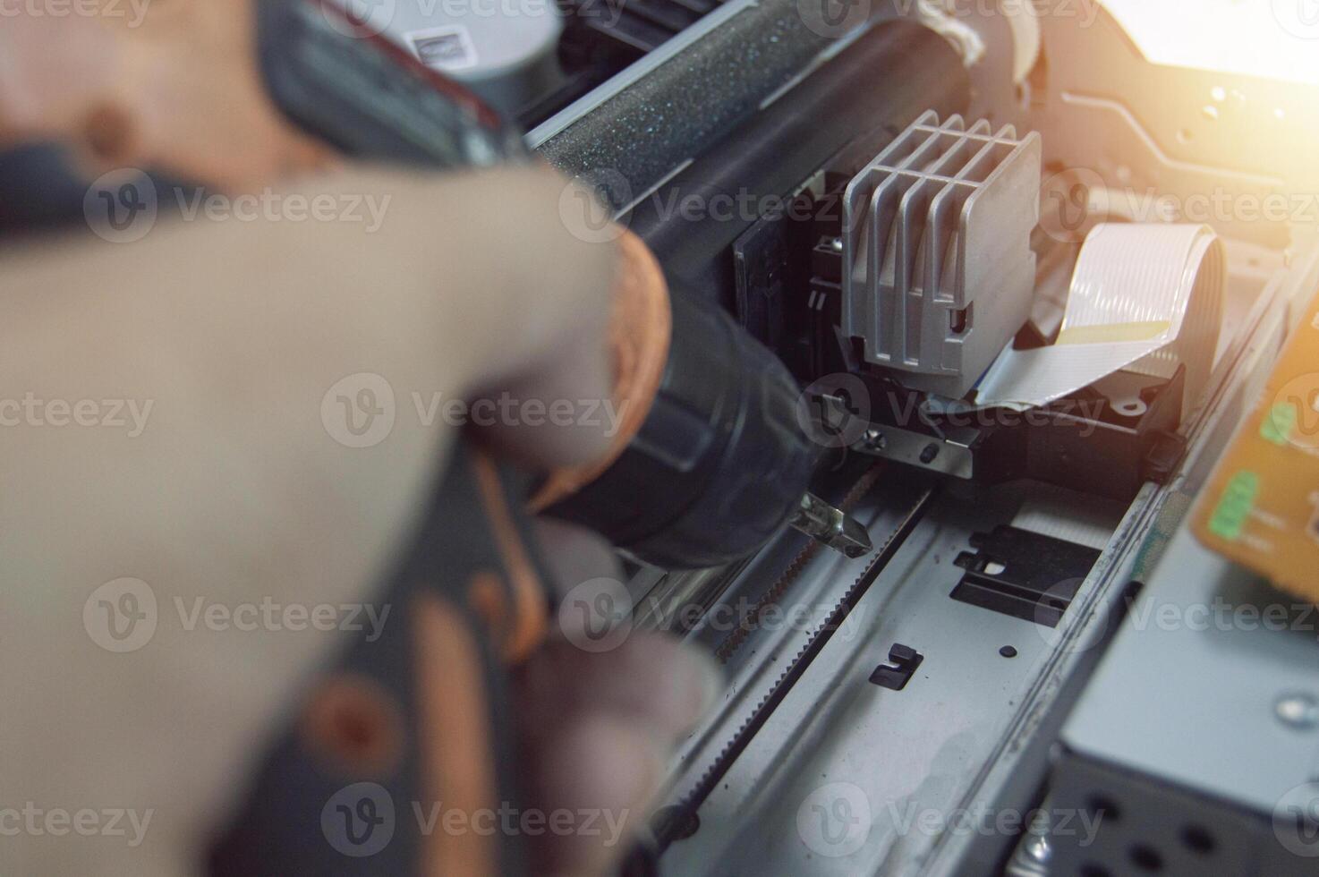 Side view of technician inspecting and repairing printer. photo