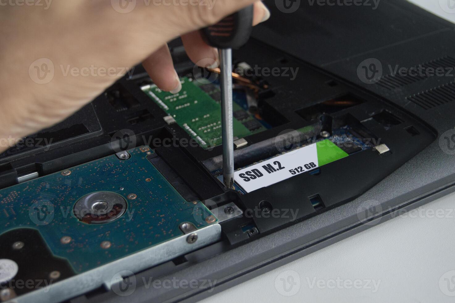 Side view of technician installing M.2 SSD hard drive. photo