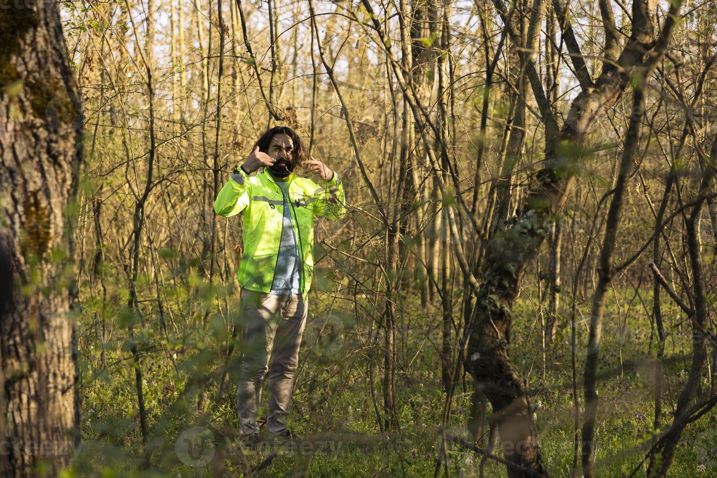 Search party leader guiding the team into the woods area to find evidence during manhunt mission, searching for a missing person. Rescue squad yelling victims name, lost in the woods. photo