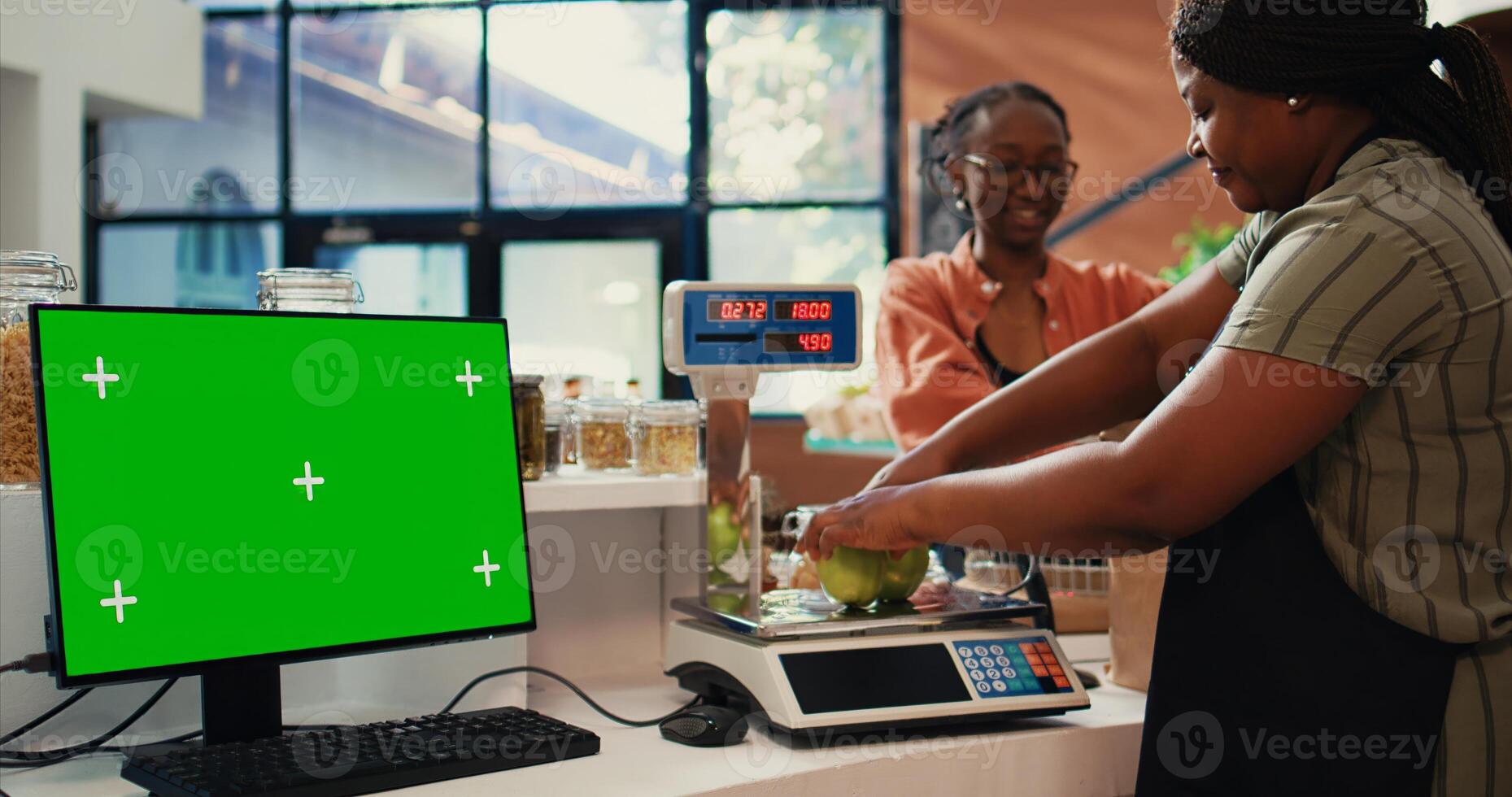 Seller serving customer at counter next to greenscreen layout, presenting blank copyspace template on monitor. Merchant using scale, having pc screen with isolated chromakey. Tripod shot. photo
