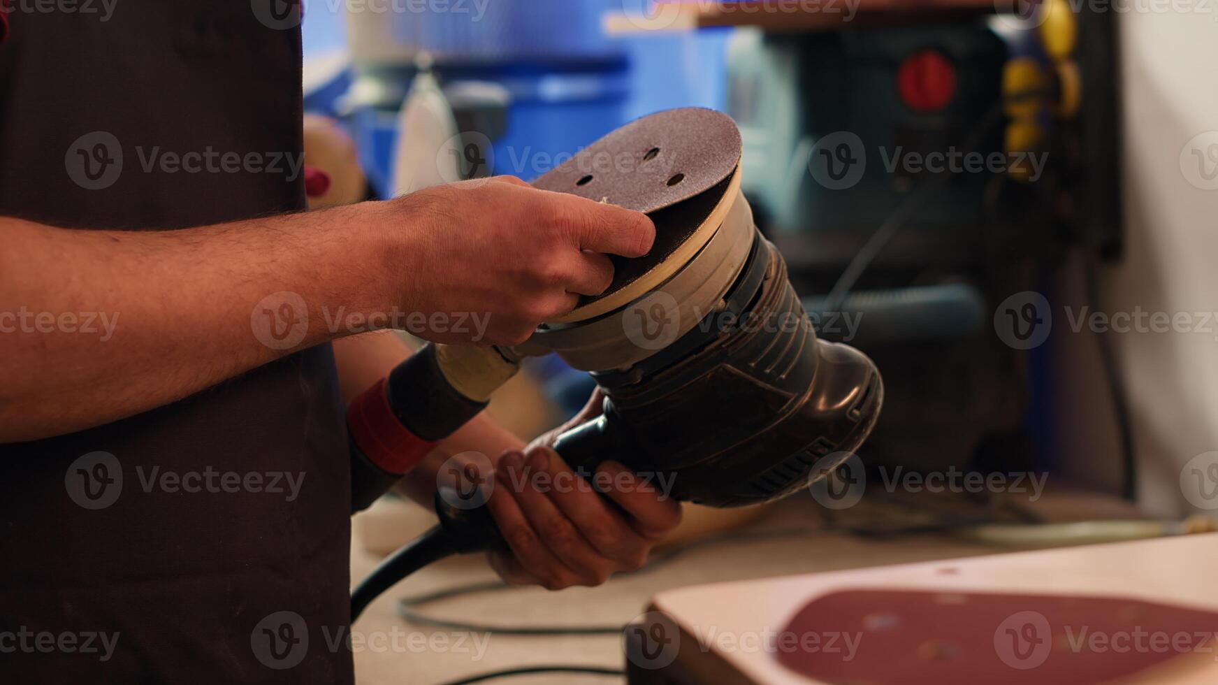 Craftsperson putting sandpaper discs on sander device to be used on smoothing wood surfaces. Woodworking expert preparing necessary gear for furniture assembling commission, close up, camera A photo