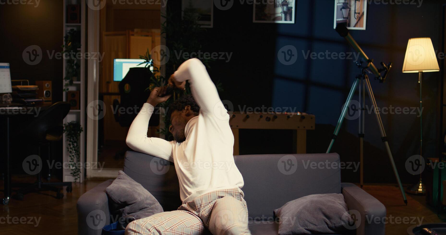 Annoyed gamer raging in frustration after losing mission while playing videogame on gaming console, ready to throw controller. African american man furiously yelling after failing to win level photo