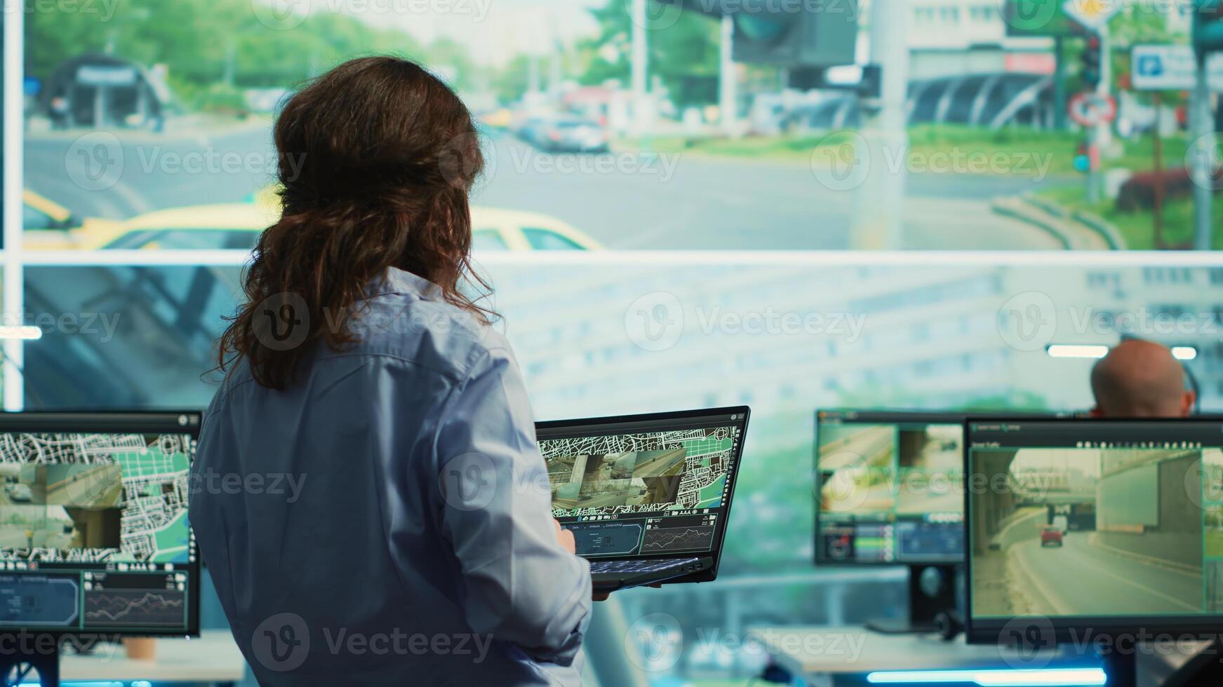 Team leader monitoring city traffic with her diverse team on a big screen, using real time surveillance footage to ensure public safety. Agency supervising CCTV security system. Camera A. photo