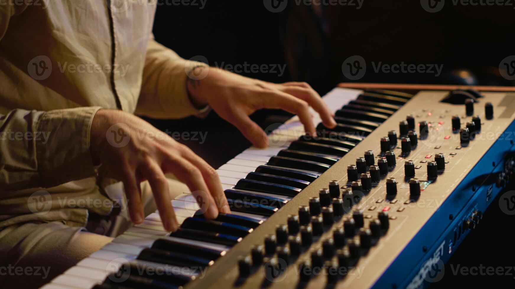 Talented artist performing in control room at studio and recording music for new album, working with mixing console and motorized faders. Musician composing new tracks on technical gear. Camera A. photo