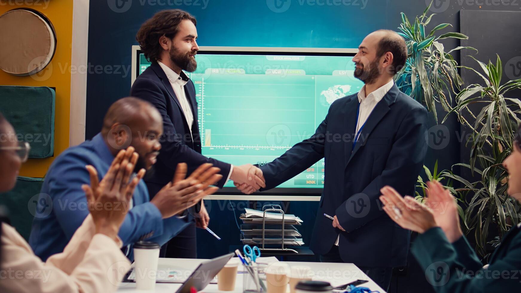 Entrepreneurs signing a new partnership contract between their firms, joining forces to capitalize on synergies. Managers collaborate to resolve specific skill gaps and development needs. Camera B. photo