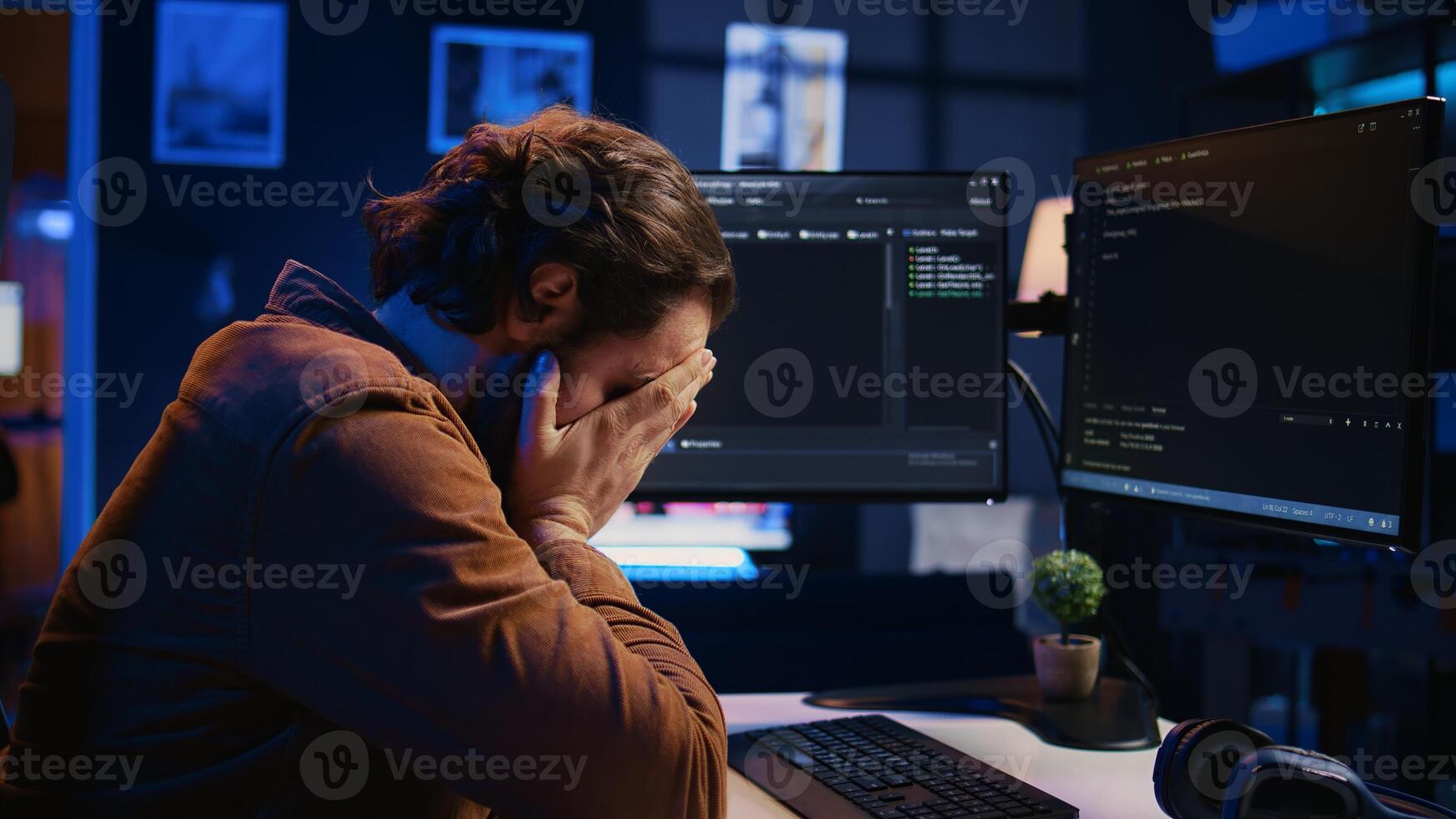 Annoyed software developer exasperated after failing to remove all bugs while coding on computer desktop. Teleworking IT specialist throwing keyboard, frustrated by script errors, camera B photo