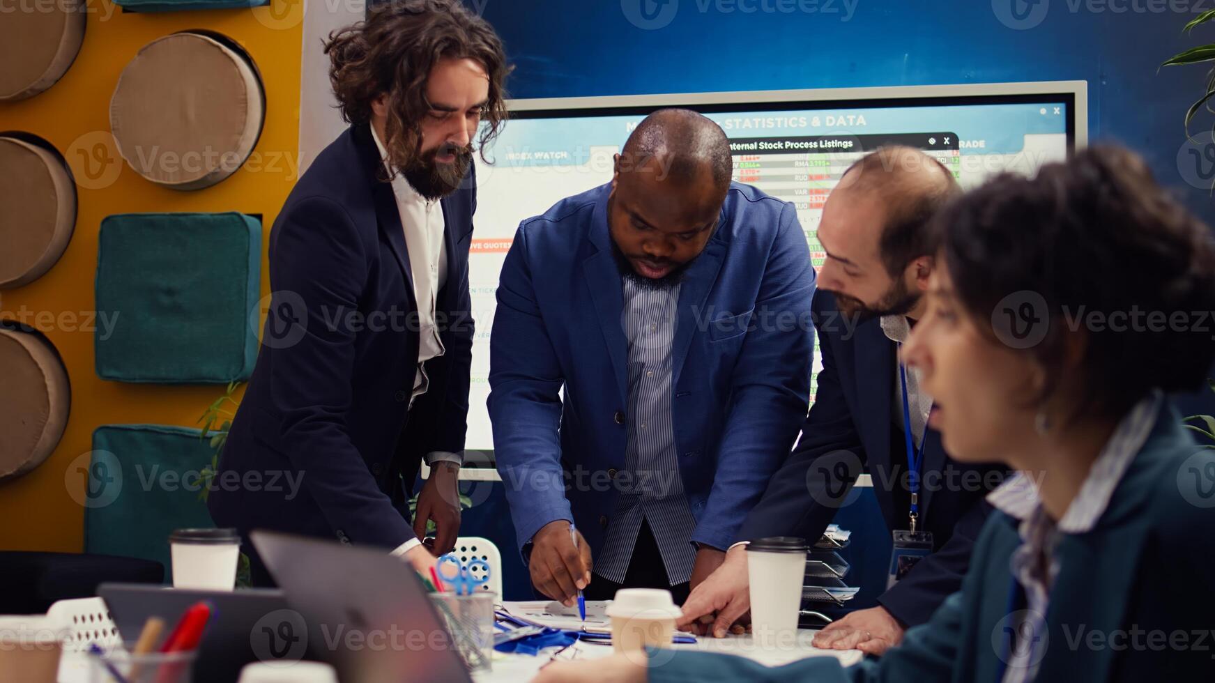 Business associates reviewing latest financial plans on documents, organizing a briefing meeting for sharing project updates and timelines to ensure progress. Coworkers making decisions. Camera B. photo