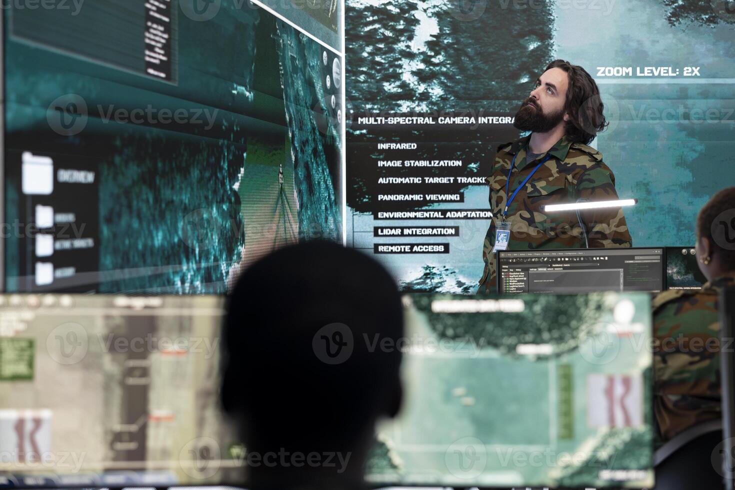 Army personnel gather intelligence for new defense operations, using a big screen with real time satellite data in military headquarters. Recruits examining important CCTV footage information. photo