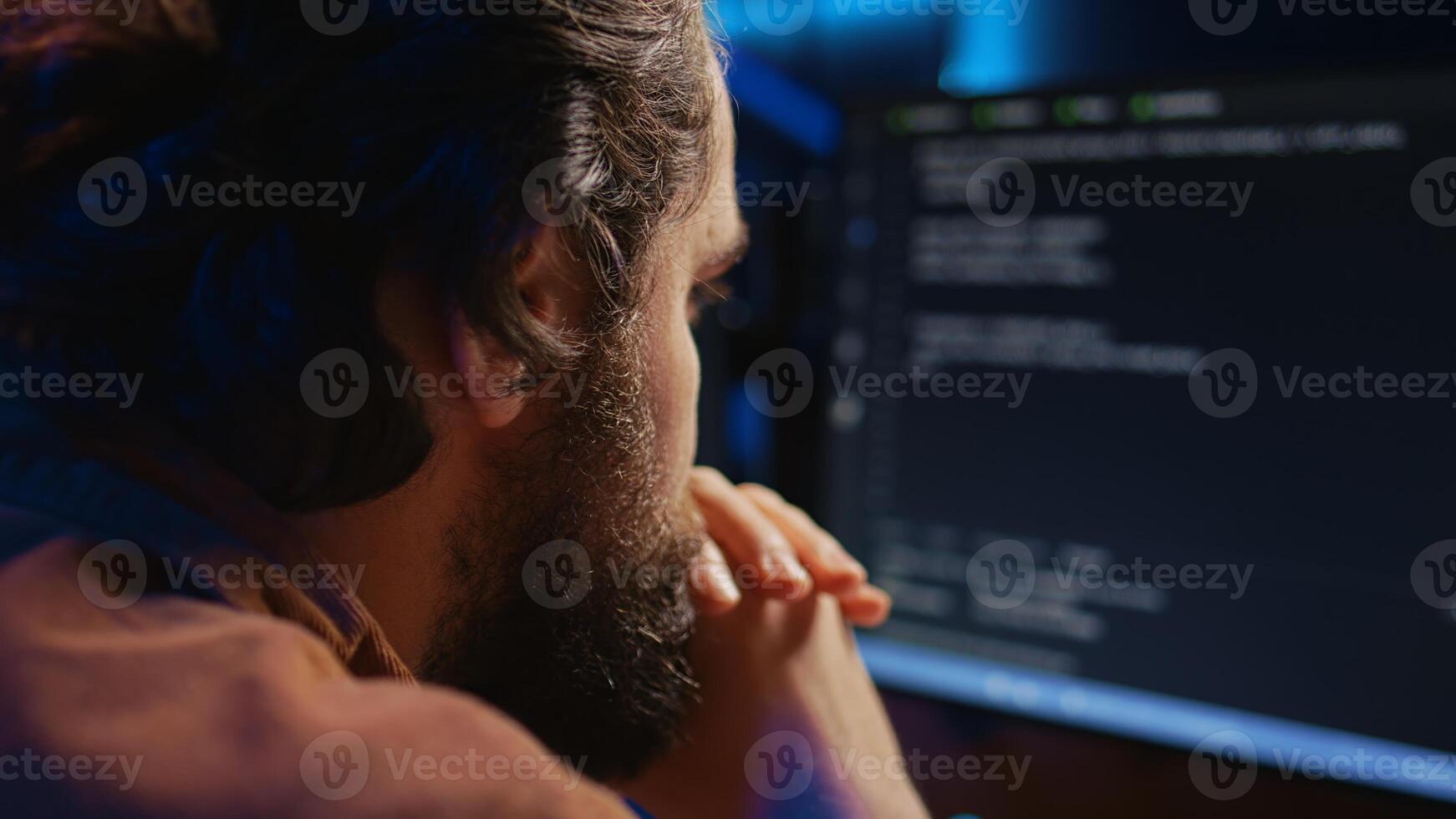 Programmer in home office concentrating on finding bugs while doing coding on computer, extreme close up shot. IT admin frowning while looking at screen, confused by errors in lines of code, camera B photo