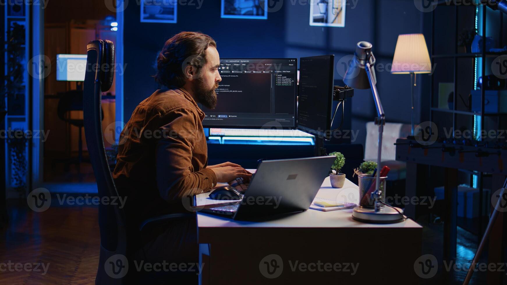 Developer pressed by deadline, drinking coffee and doing multitasking to finish developing PC code. Caffeinated IT specialist solving database error using multiple desktop and laptop screens, camera B photo