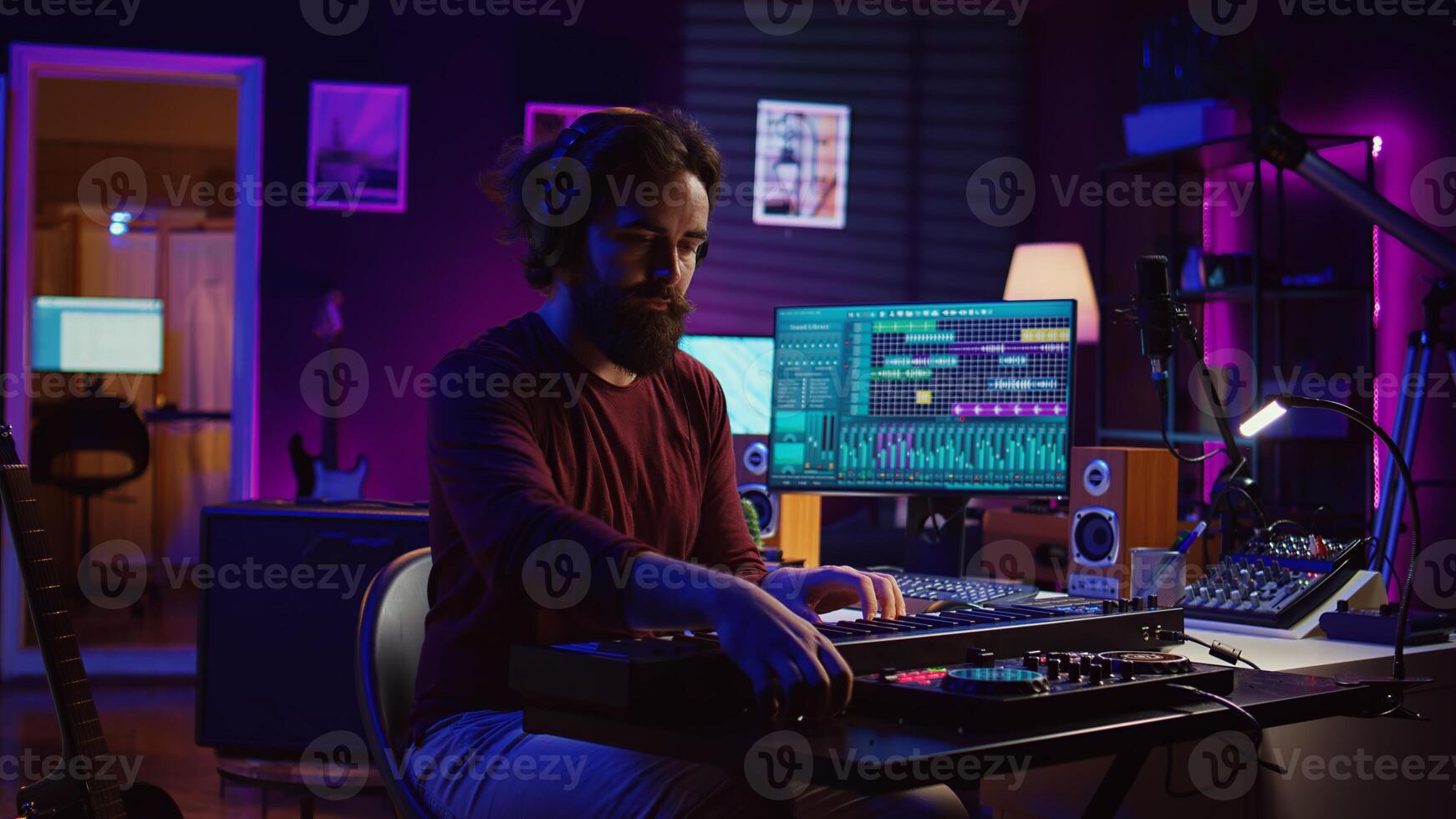 Young artist composing a song on electronic piano keyboard at home recording studio. Audio engineer playing MIDI controller, working on producing a soundtrack, soundboard tools. Camera B. photo