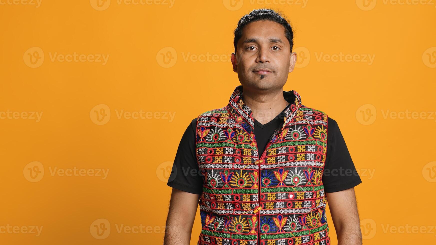 Portrait of cheerful friendly indian man smiling, looking pleased, isolated over studio background. Happy expressive asian person in traditional attire grinning, feeling satisfied, camera A photo