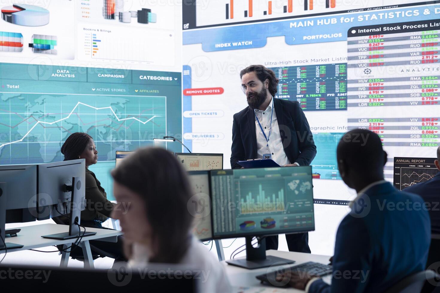 Company employees employing big data used in solving tasks, studying infographics on a huge display. Business analysts reviewing current situation numbers for annual reports. photo